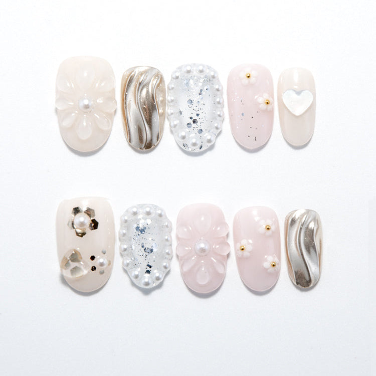 Creamy nude press-on nails with 3D floral design, pearl accents, and gold wave patterns