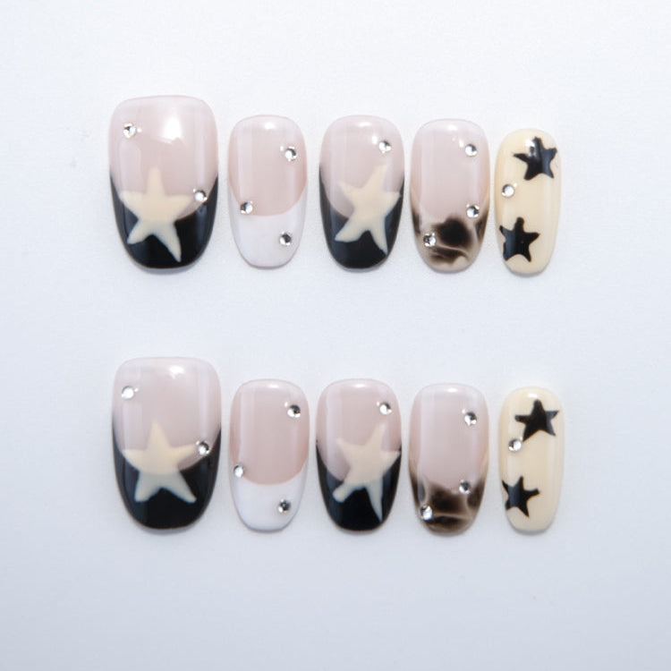 Black and nude press-on nails with large white star and rhinestone accents