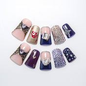 Purple and gold press-on nails with leopard print and large rhinestone accents