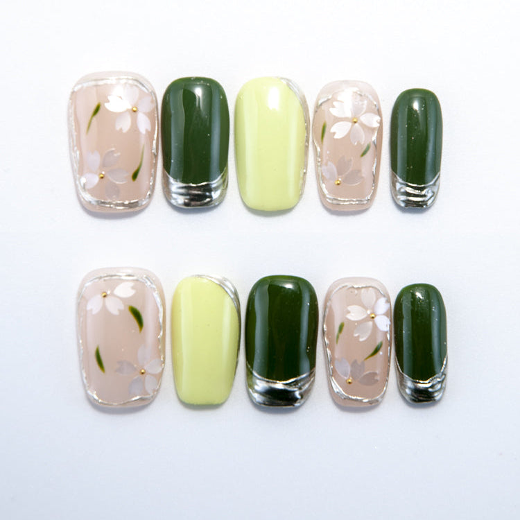 Green and nude press-on nails with white daisy floral nail art
