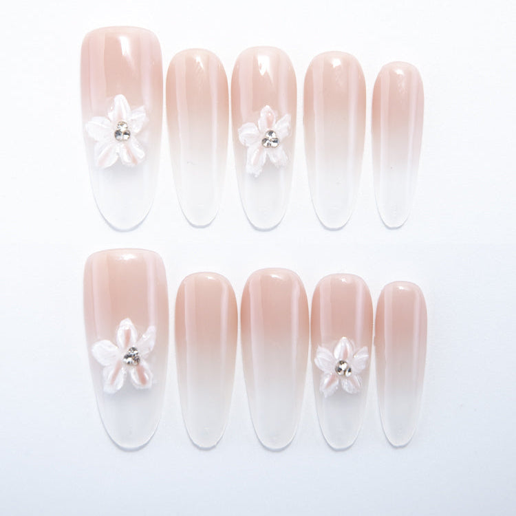 Nude pink ombre press-on nails with 3D white flower and rhinestone center