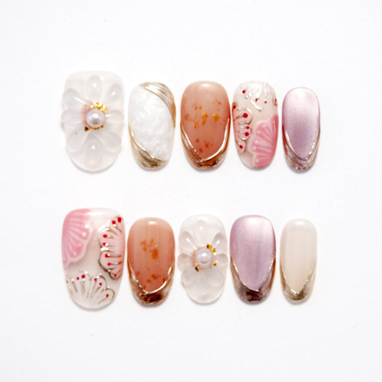 Handmade pink and nude nails with gold accents and seashell-inspired art
