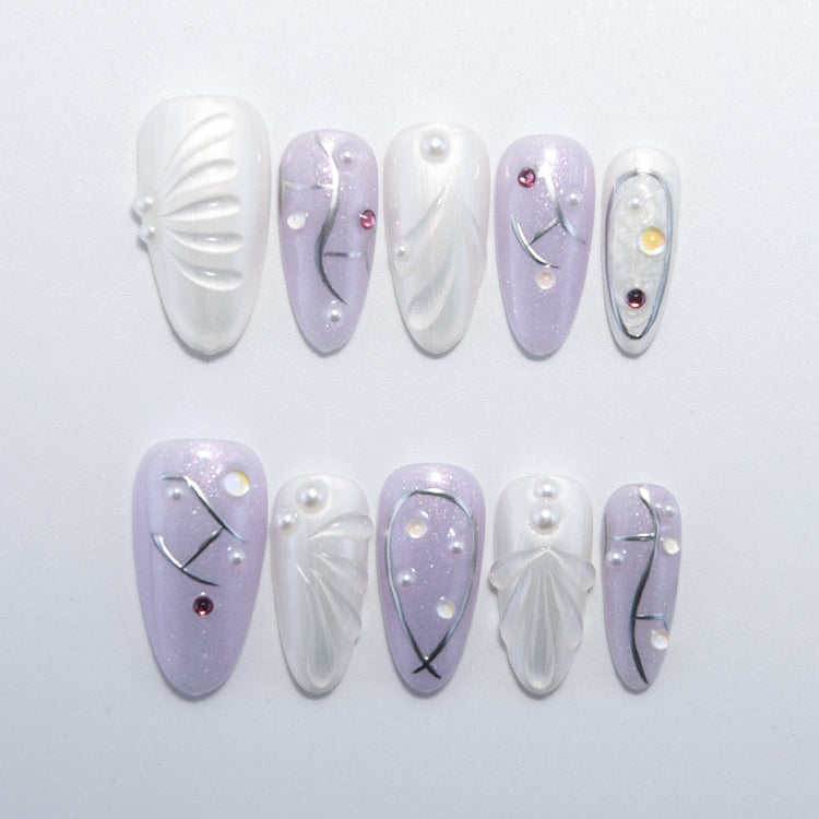 Lavender and white press-on nails with embossed petal design and pearl accents