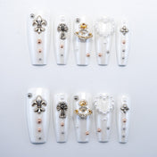 Handmade white nails with 3D pearl heart, cross, and royal emblem designs