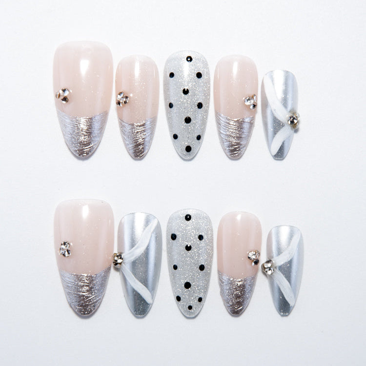 Silver French tip press-on nails with nude base, black polka dots and rhinestone accents