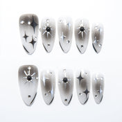 Black and white ombre press-on nails with starburst and rhinestone accents