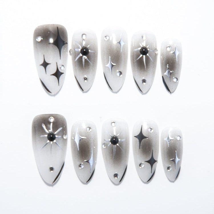 Black and white ombre press-on nails with starburst and rhinestone accents