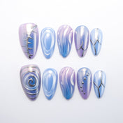 Futuristic press-on nails in blue and purple with metallic swirl design